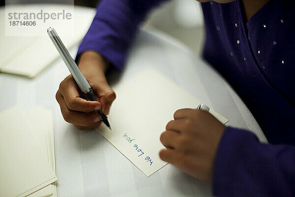 Ein junges Mädchen schreibt eine Notiz mit der Aufschrift: