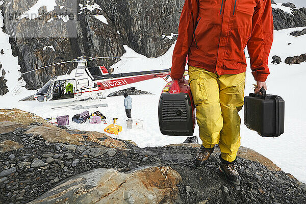 Glaziologen entladen Ausrüstung aus einem Hubschrauber in ihrem Feldlager am Columbia-Gletscher in der Nähe von Valdez  Alaska.