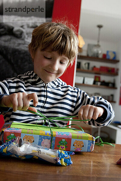 Ein Junge öffnet aufgeregt ein Geschenk