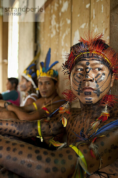 Ein als Jaguar bemalter Oro-Win-Mann und andere Mitglieder der Gemeinschaft entspannen sich nach einem großen Fest während eines traditionellen Festes