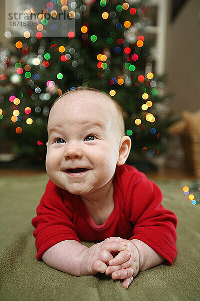 Ein Baby lächelt für ein Weihnachtskartenporträt.