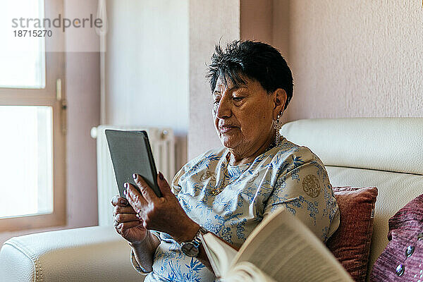 Lateinamerikanische Frau liest mit einem elektronischen Buch