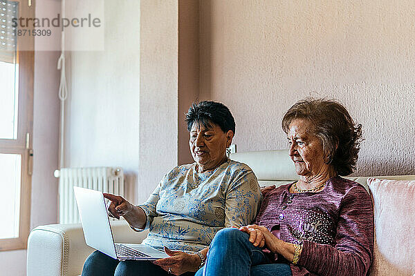 Zwei ältere Frauen schauen sich einen Film auf dem Laptop an