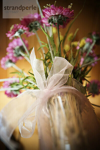 Tiefansicht einer Schleife auf einer Vase mit künstlichen Blumen.