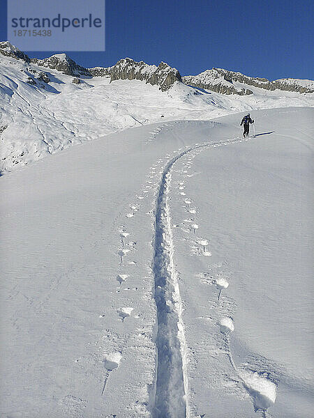 Ein Skibergsteiger wandert im Hinterland der Schweizer Walliser Alpen.