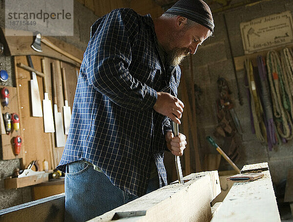 Ein Holzbauer verwendet einen Einsteckmeißel  um eine Einsteckverbindung in seiner Holzwerkstatt in Deforest  WI  zu reinigen.