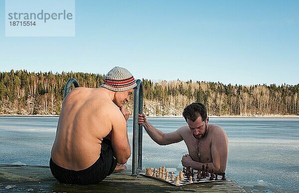 Zwei Männer spielen Schach beim Kaltwasserschwimmen in Skandinavien