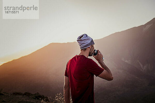 Wanderer trinkt Wasser bei Sonnenuntergang im Guajara-Gebirge  El Teide
