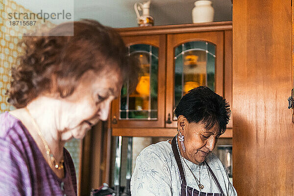 Zwei ältere Freundinnen kochen gemeinsam in der Küche