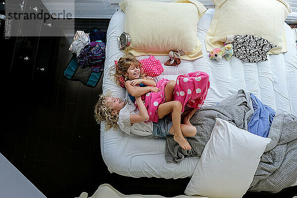 Schwestern liegen zusammen auf einer aufblasbaren Matratze und lachen und sind glücklich zusammen