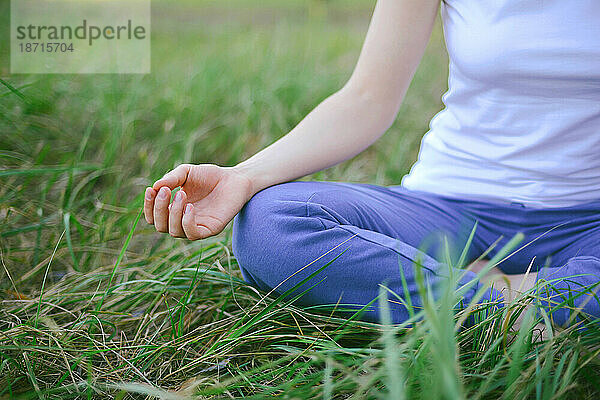 Frau praktiziert Yoga im Freien