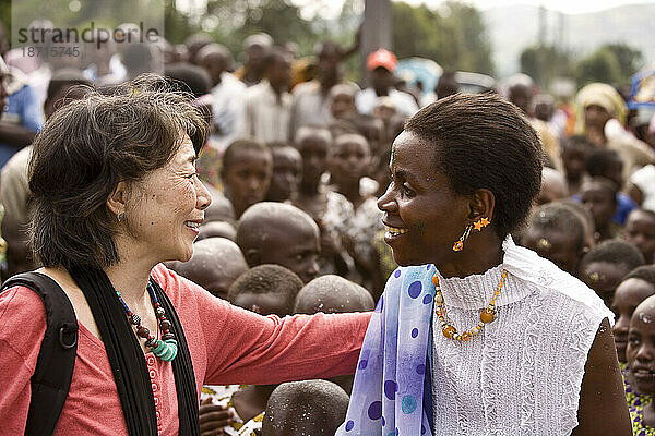 Ein Künstler und Aktivist begrüßt einen ruandischen Freund während der Einweihung des Rugereo Genocide Memorial.