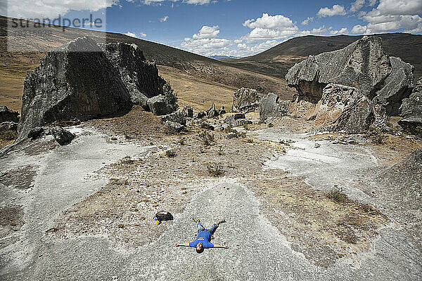 Ein Mann liegt zwischen einigen Felsen in Hatun Machay  Peru.