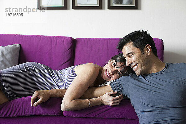 Ein Mann und eine Frau entspannen sich auf einem Sofa.