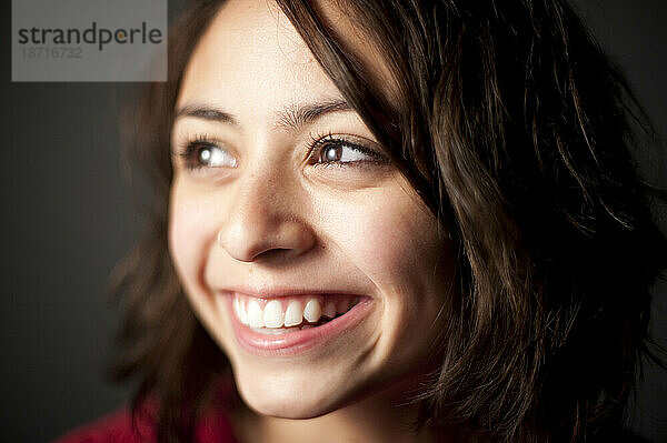 Studioporträt eines lächelnden 15-jährigen Latina-Mädchens.