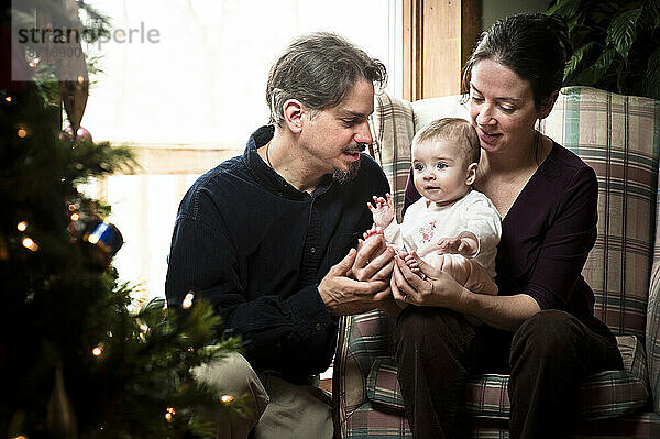 Ein Porträt des ersten Weihnachtsfests eines Babys mit seinen Eltern.