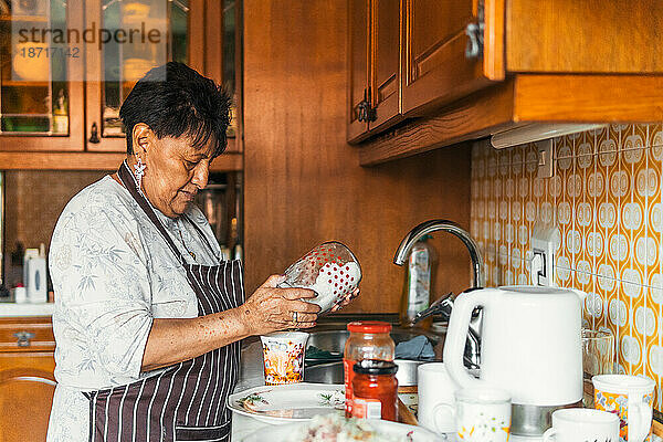 Ältere lateinamerikanische Frau kocht zu Hause