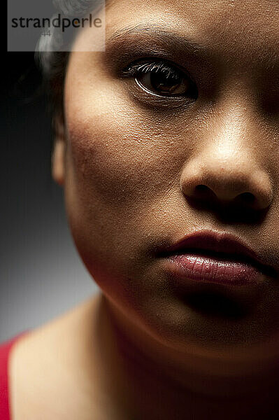 Studio-Nahaufnahmeporträt einer 21-jährigen asiatischen Frau.
