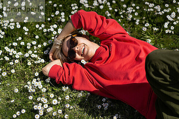 Sommerporträt einer Frau auf einem Rasen voller Gänseblümchen.