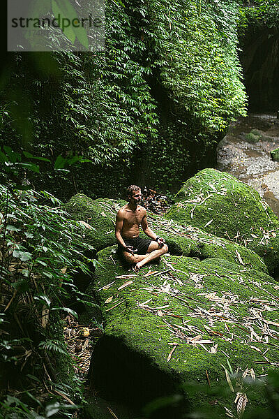 Der Mensch meditiert in der Natur im Dschungel. Atmung und Gleichgewicht.