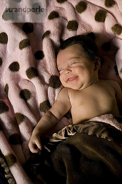 Ein Baby lächelt im Schlaf