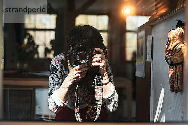 Fotografin macht zu Hause ein Selbstporträt im Spiegel