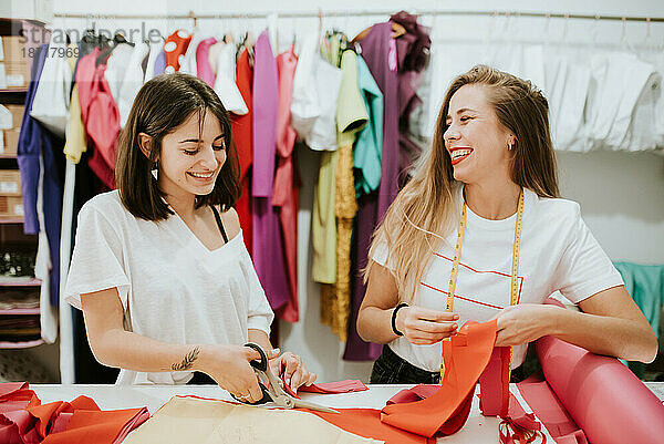 Zwei Frauen haben gemeinsam Spaß bei der Arbeit. Modedesigner