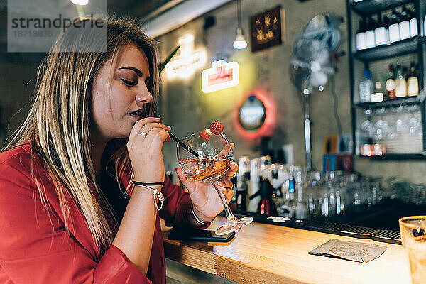 Blondes Mädchen in einer Cocktailbar.