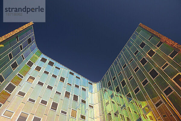 Erstaunlich farbenfrohe  reflektierende Fassade eines modernen Bürogebäudes in der Sonne