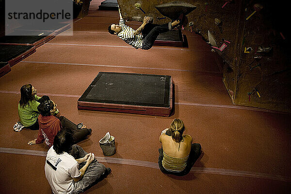 Kletterer bouldern in einer Indoor-Kletterhalle.