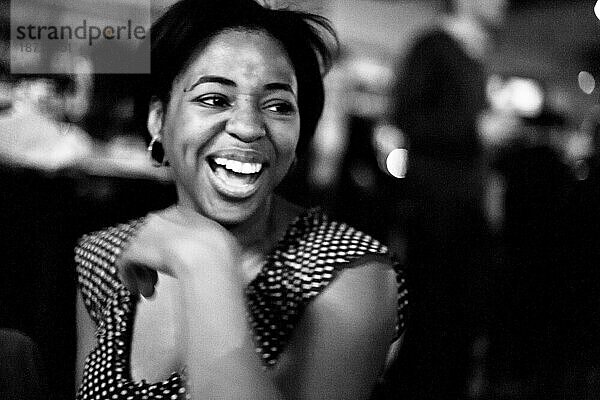 Eine junge  stilvolle Afroamerikanerin lacht in einer Bar in Seattle  Washington.