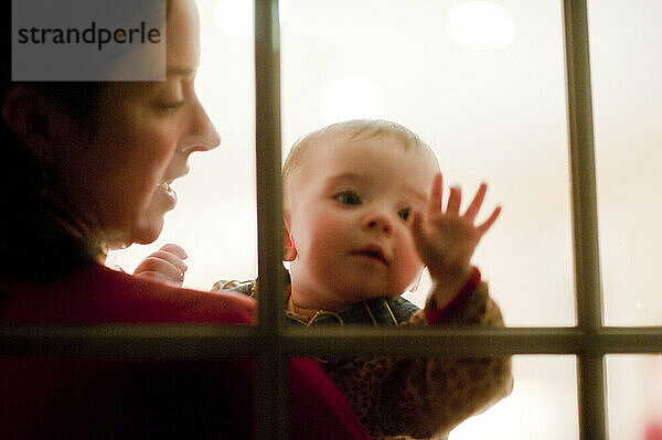 Ein Baby und seine Mutter werden von Fensterscheiben eingerahmt.