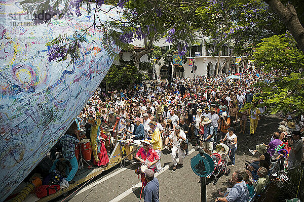 Menschenmassen verfolgen den letzten Festwagen  eine Parade in Santa Barbara. Die Parade umfasst extravagante Festwagen und Kostüme.