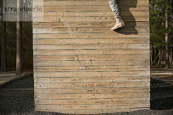 Das Bein eines Soldaten baumelt in der Grundausbildung an der Wand eines Selbstvertrauenskurses.