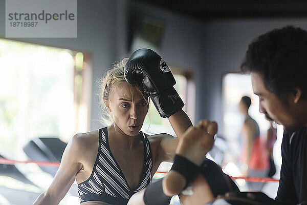 Junge Frau übt Kickboxen mit Trainer  Seminyak  Bali  Indonesien