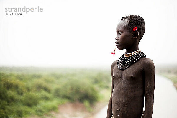 Ein Porträt eines kleinen Jungen in traditioneller Kleidung und Dekoration im Omo-Tal  Äthiopien.