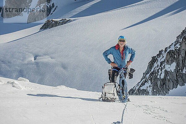 Ein erfahrener Alpinist macht eine Pause hoch oben in den Alpen