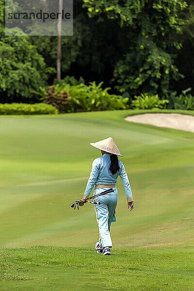 Rückansicht einer Frau  die auf dem Golfplatz läuft
