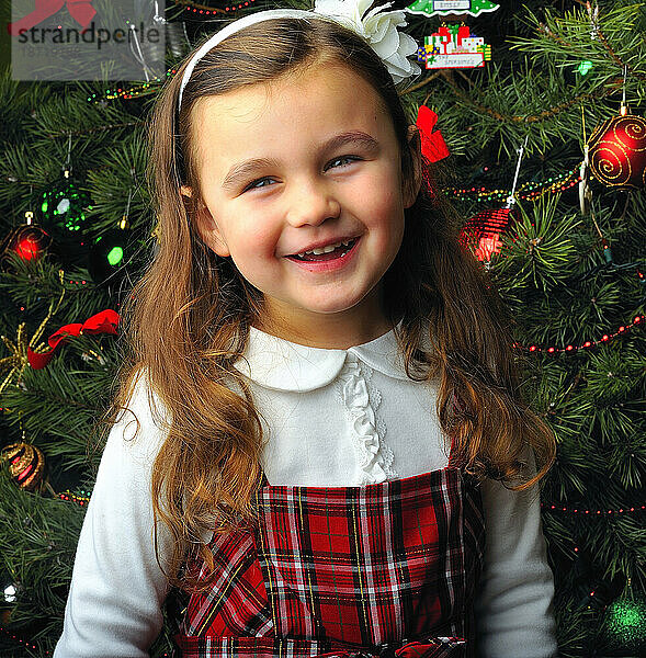 Lächelndes Mädchen am Weihnachtsbaum