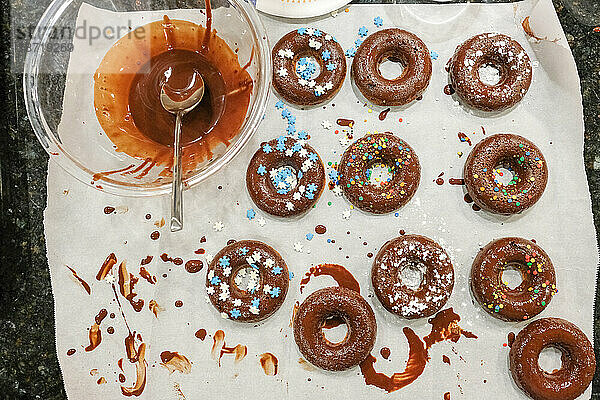 Blick von oben auf hausgemachte Donuts und Schokolade auf der Küchentheke
