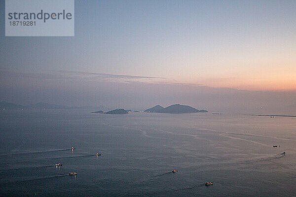 Bei Sonnenuntergang fahren Boote zum Angeln hinaus.