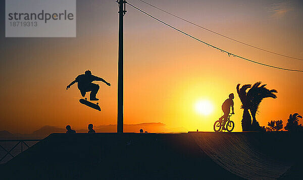 Eine Gruppe Teenager auf Skateboard im Sommer  Silhouette nicht wiederzuerkennen.