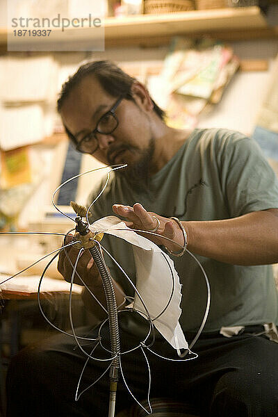 Man makes lamps out of handmade paper.