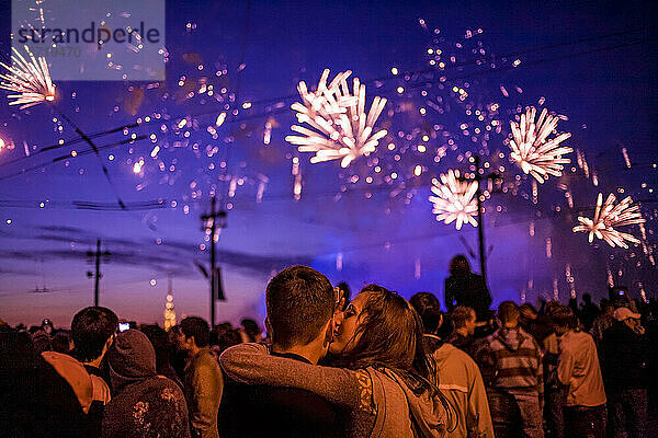 Junges Paar küsst sich unter Feuerwerk