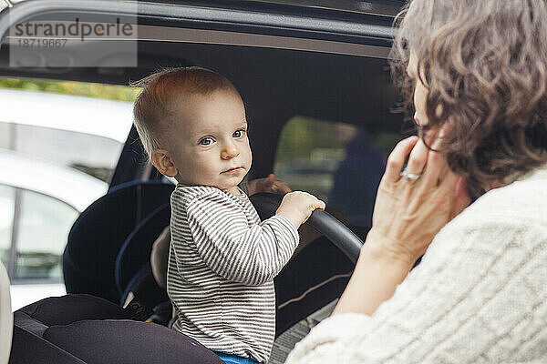 Eine Mutter setzt ihr Baby in den Autositz eines Minivans