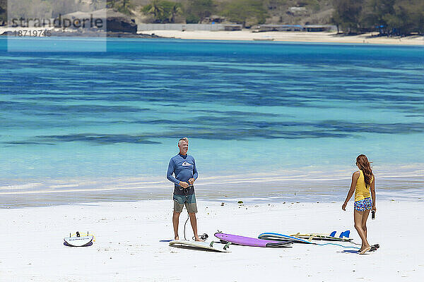 Männliche und weibliche Surfer am Strand