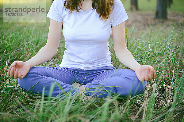 Frau praktiziert Yoga im Freien