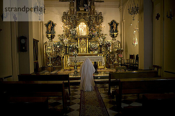 Eine weiß gekleidete Klosternonne betet in der St.-Gregor-Kirche in Granada  Andalusien  Spanien.