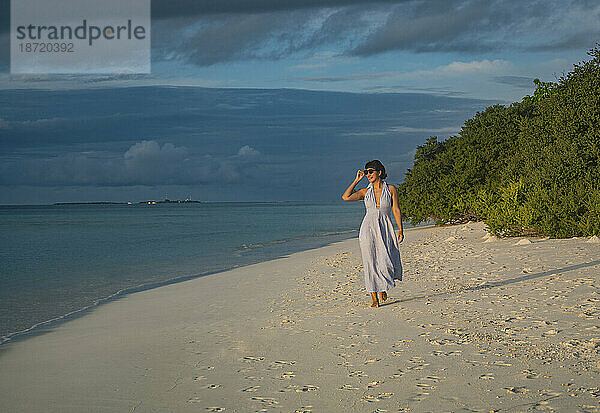 Schöne Frau  die an einem Strand auf den Malediven spaziert