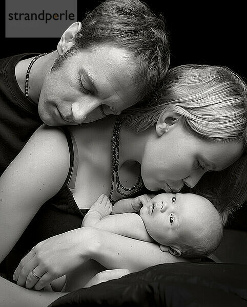 Salmon Arm  BC – Eine Mutter und ein Vater kuscheln mit ihrem neugeborenen Jungen – ein warmes Schwarz-Weiß-Porträt.
